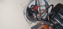 Puszka elektryczna z kilkoma kolorowymi przewodami i gniazdem łącznika.