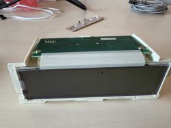 Uszkodzony wyświetlacz elektroniczny leżący na biurku.