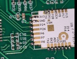 Close-up of a printed circuit board with an attached module and visible soldering.