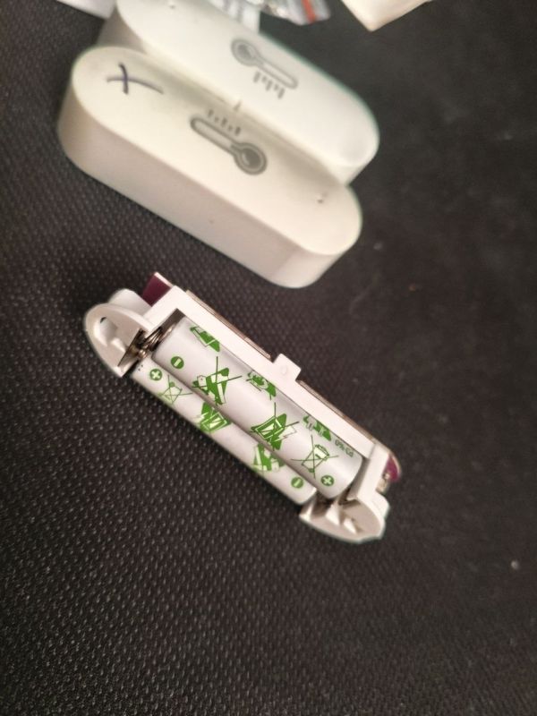 Zigbee sensor battery module with visible cell and white enclosures in background