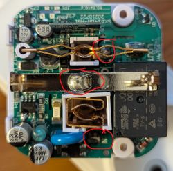 Close-up of smart plug PCB with solder points marked in red circles