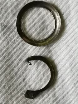 Damaged snap ring and washer on a white background.