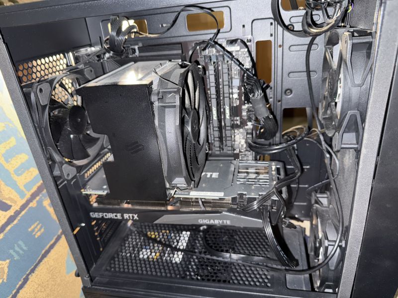 Wnętrze komputera z widoczną płytą główną Gigabyte i wentylatorami RGB