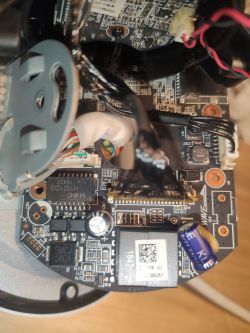 Zbliżenie na wewnętrzną elektronikę urządzenia, widoczna płytka drukowana z komponentami.