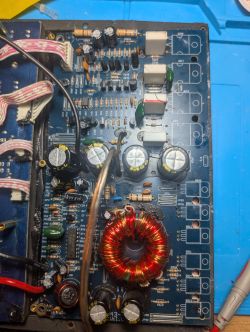 Wnętrze modułu wzmacniacza: płytka PCB z dużymi kondensatorami i cewką toroidalną
