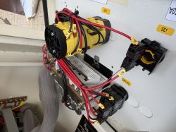 Widok zbliżony na elementy elektryczne i okablowanie wewnątrz szafy sterowniczej maszyny