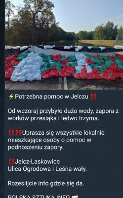 Zapora z worków z piaskiem nad rzeką w Jelczu-Laskowicach z apelem o pomoc w naprawie.