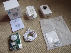 PIR Motion Sensor P06 Set with XR3 Module PIR motion sensor P06 with accessories and manual on a carpet.
