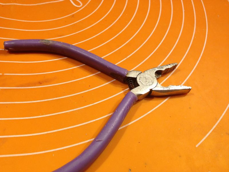 Fioletowe kombinerki na pomarańczowej macie z białymi okręgami