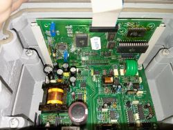 Zbliżenie na płytkę drukowaną w urządzeniu z zamontowanymi podzespołami elektronicznymi.