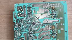 Płytka PCB z widocznymi ścieżkami, komponentami i oznaczeniem biegunowości.