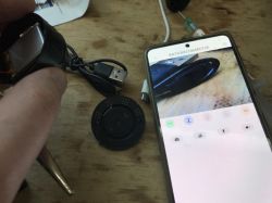 Inspection camera connected to smartphone, electronic components on wooden desk