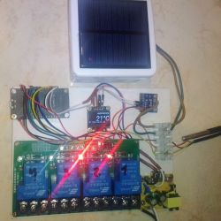 Prototyp sterownika PV/CWU na płytce z czterema przekaźnikami, wyświetlaczem OLED i małym panelem solarnym