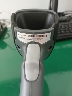 Zbliżenie na czytnik kodów kreskowych S100 z etykietą i kodem kreskowym.