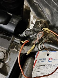 Zbliżenie na silnik Hyundai i30 z luźno zwisającymi przewodami i etykietą serwisu olejowego.