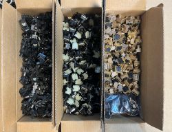 Three boxes filled with different electronic sensors of various colors and shapes.