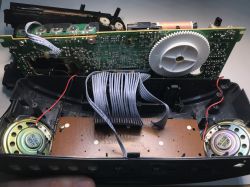 Wnętrze rozebranego radiobudzika z widoczną elektroniką i głośnikami
