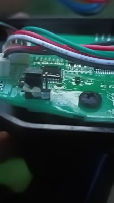 Zbliżenie na płytkę drukowaną z kolorowymi przewodami i przełącznikiem.