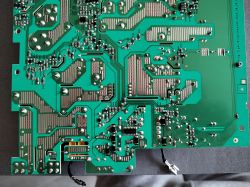 Zbliżenie na zieloną płytkę drukowaną płyty indukcyjnej Electrolux, widoczne ścieżki i komponenty elektroniczne.