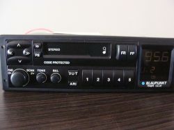Radio samochodowe Blaupunkt Trier CC31 stojące na drewnianym blacie, z widocznym panelem i wyświetlaczem.