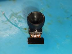 Camera module with large lens on a blue surface