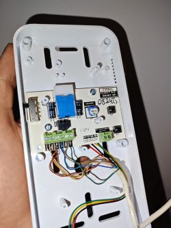 Wnętrze panelu domofonu z widocznymi przewodami i elektronika.