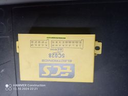 Zdjęcie prostokątnego, żółtego obudowy modułu elektronicznego 5C028 z oznaczeniami i schematem połączeń.