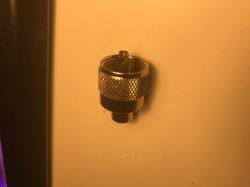 Metalowa końcówka przypominająca nasadkę z gwintem zewnętrznym i radełkowanym uchwytem.
