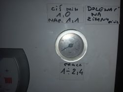 Manometr kotła z ciśnieniem około 3 bary oraz instrukcjami w tle.