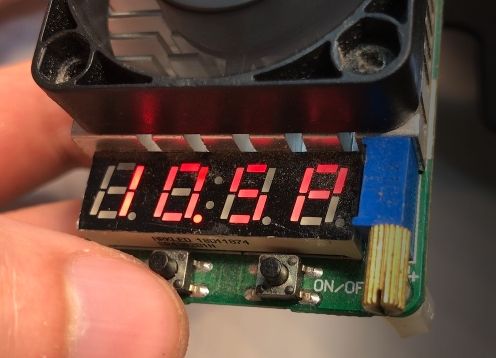 Close-up of a PCB module with LED display showing “0.0.0.A” and an ON-OFF button