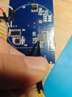Hands holding needles connected to a circuit board