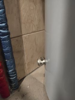 Vaillant tank with visible heater opening installed close to the wall.