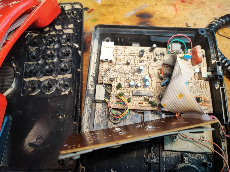 Zdemontowane wnętrze telefonu Proton T1332 z częściami elektronicznymi widocznymi na płytce.