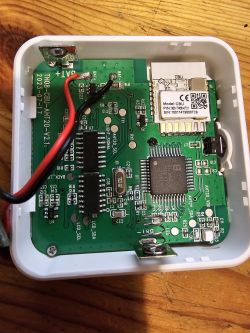 Close-up of a PCB with soldered components and a wireless module in a white casing.