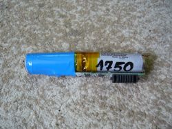 Bateria litowo-jonowa z oznaczeniem „1750” na obudowie na tle dywanu.
