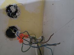 Odsłonięte przewody elektryczne z chaotycznym połączeniem i kostkami łączeniowymi.