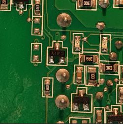 Zbliżenie zielonej płytki PCB z elementami SMD; widoczny układ z nadrukiem „A4W 98”