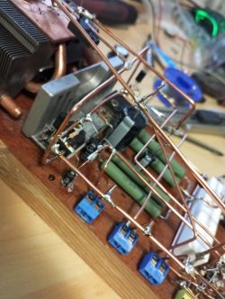 Amatorski wzmacniacz na drewnianej podstawie z użyciem różnych elementów elektronicznych.