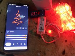 Smartphone with a light control app next to a set of red LED lights.