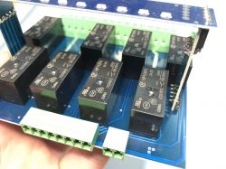 Printed circuit board with HF115F-K relays and green screw terminals.