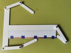 PCB positioning jig with printed paper and tape on a green background