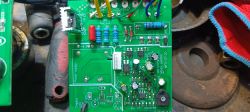 Zbliżenie na płytkę elektroniczną z elementami elektronicznymi i kolorowymi przewodami.