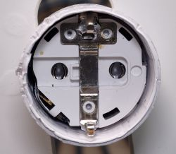 View of the interior of a disassembled smart plug showing metal and plastic components.