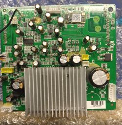 Zielona płytka drukowana z różnymi komponentami elektronicznymi, takimi jak kondensatory, rezystory i metalowy radiator.