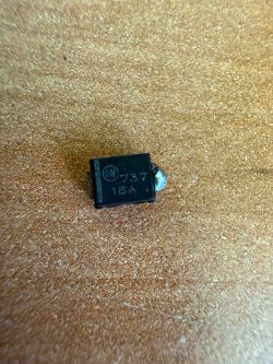 Zbliżenie na mały, czarny element elektroniczny z oznaczeniem ON 737 18A umieszczony na powierzchni.