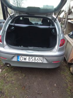 Otwarte tylne drzwi bagażnika szarego samochodu.