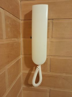 Biały unifon zamontowany na ścianie.