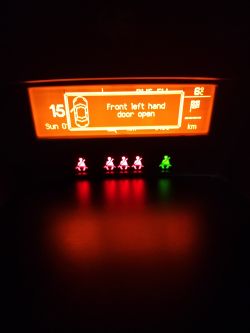 Wyświetlacz Peugeot 207 z komunikatem o otwartych drzwiach kierowcy oraz świecącymi kontrolkami