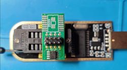 USB programmer with TFXTDOL socket and adapter for SPI 25XXX memory on a blue background.