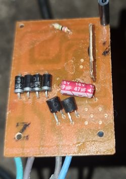 Płytka drukowana z kilkoma komponentami elektronicznymi, w tym diodami i kondensatorem.